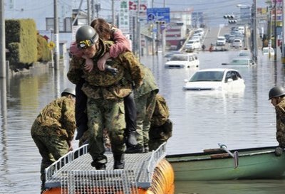 Soldiers of Japan Self Defense Forces rescue a tsunami victim from a flooded area in Ishinomaki, Miyagi Prefecture, Sunday, March 13, 2011.