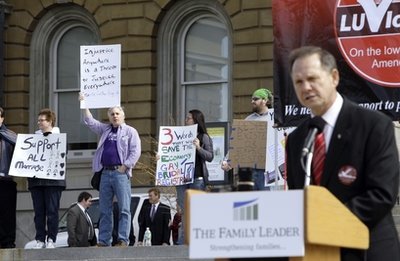 Gay marriage supporters, left, look on as Alabama Supreme Court Justice Roy Moore speaks during an anti gay-marriage rally sponsored by The Family Leader, Tuesday, March 15, 2011, at the Statehouse in Des Moines, Iowa. About 500 opponents of gay marriage rallied outside the Statehouse to pressure lawmakers to approve a statewide vote on amending the constitution to ban gay marriage.