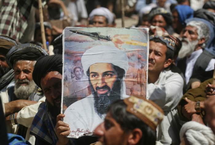 A supporter of the Pakistani religious party Jamiat-e-ulema-e-Islam holds an image of al-Qaida leader Osama bin Laden during an anti-U.S. rally on the outskirts of Quetta May 6, 2011.