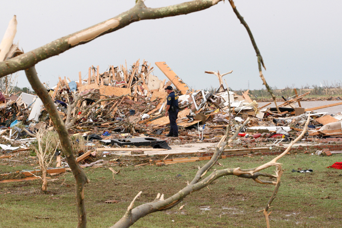 Credit : A police officer looks over a home after a tornado ripped through the Falcon Lake area of Piedmont, Oklahoma on May 24, 2011.
