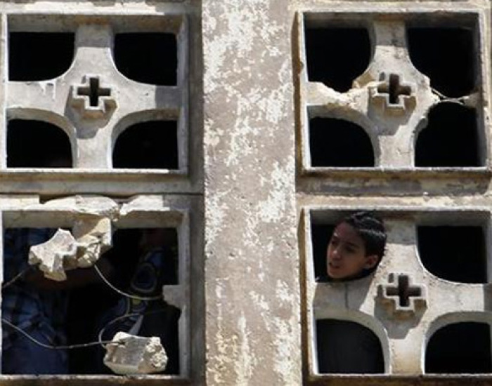 A Coptic Christian boy looks out of the Saint Mary Church which was set on fire during clashes between Muslims and Christians in the heavily populated area of Imbaba in Cairo.