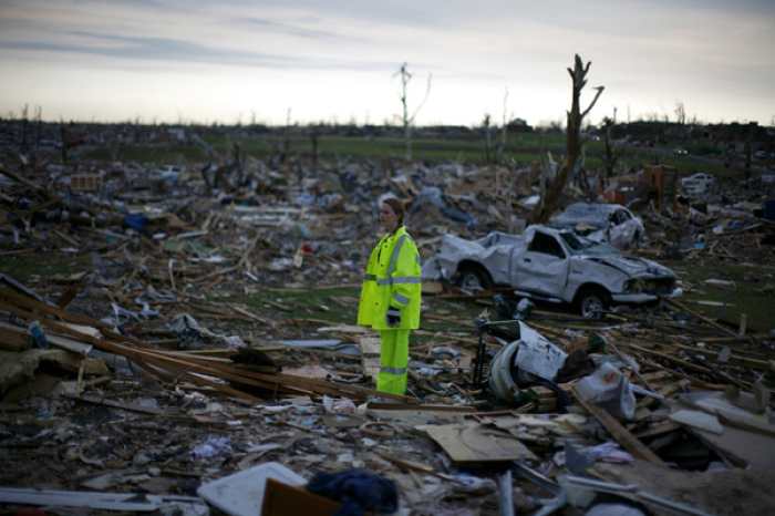 A volunteer stands in a destroyed neighborhood in Joplin, Missouri May 27, 2011. The death toll from a monster tornado that savaged Joplin, Missouri, rose to 142.