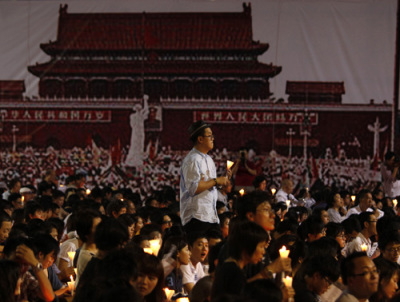 A protester stands in front of a backdrop showing Beijing's Tiananmen Square in 1989 during a candlelight vigil at Hong Kong's Victoria Park June 4, 2011, to mark the 22nd anniversary of the military crackdown of the pro-democracy movement in Tiananmen Square.