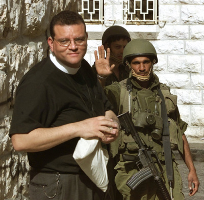 An Israeli soldier (R) turns back the Rev. Canon Andrew White, the 'vicar of Baghdad,' and envoy to the Archbishop of Canterbury as he tries to enter the Church of Nativity, Bethlehem, April 14, 2002.