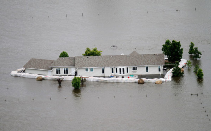 A home is seen submerged in flood waters from the Souris River, after sand bags failed to hold the water back in Minot, North Dakota June 24, 2011. Federal officials sharply increased plans to release more water on the swollen Souris River on Thursday, adding up to three feet to the expected peak of flooding at Minot, North Dakota, where thousands of homes already have been evacuated.