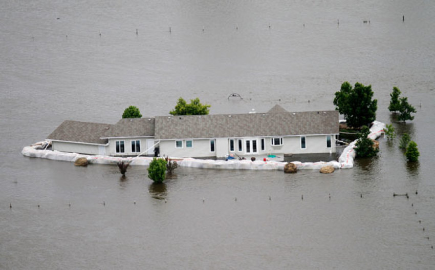 A home is seen submerged in flood waters from the Souris River, after sand bags failed to hold the water back in Minot, North Dakota June 24, 2011. Federal officials sharply increased plans to release more water on the swollen Souris River on Thursday, adding up to three feet to the expected peak of flooding at Minot, North Dakota, where thousands of homes already have been evacuated.