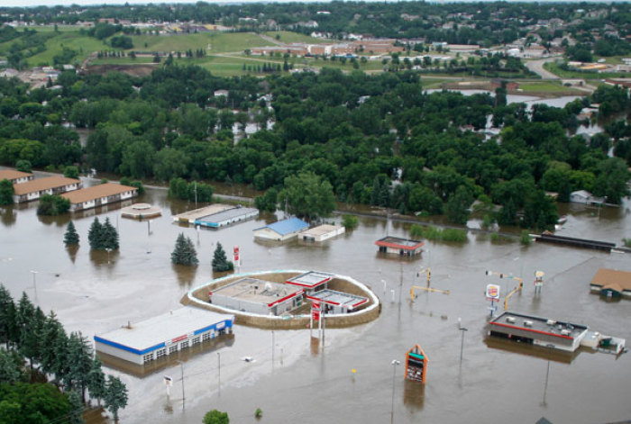 A gas station remains protected with a levee in a business district in a flooded area of Minot, North Dakota, as flood water from the Souris River spills over levees and dikes June 24, 2011.