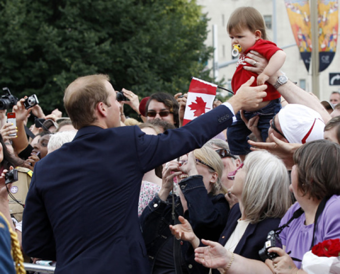 Britain's Prince William greets a child in the crowd following a ceremony at the National War Memorial in Ottawa June 30, 2011.