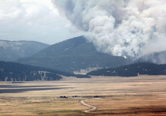 Smoke from the Las Conchas wildfire rises behind the The Valles Caldera National Preserve near Los Alamos, New Mexico. The fire has charred the thick pine woodlands on the slopes of the Jemez Mountains since erupting on Sunday near the Los Alamos National Laboratory.