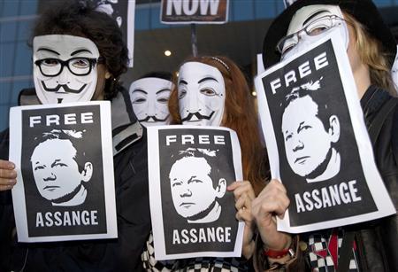 WikiLeaks supporters hold pictures in support of WikiLeaks founder Julian Assange and wear masks of the "Anonymous" internet activist group during a demonstration in front of the British Embassy in Madrid.