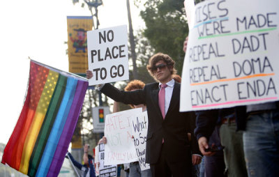 Activists hold signs during a rally outside the Beverly Hilton hotel, where U.S. President Barack Obama was attending a Democratic party fundraiser, in Beverly Hills, California May 27, 2009. California's supreme court backed a ban on gay marriage on Tuesday, upholding the voter-approved Proposition 8 defining marriage as between a man and a woman, but said the marriages last year of 18,000 same sex couples were still legal.
