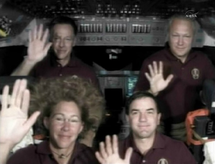 The crew of the space shuttle Atlantis Commander Chris Ferguson, Sandy Magnus, Rex Walheim and Pilot Doug Hurley wave.