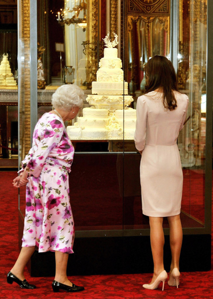 Britain's Queen Elizabeth (L) and Catherine, the Duchess of Cambridge, look at the part original, part replica royal wedding cake made for the wedding of Britain's Prince William and Kate Middleton, as they view the summer exhibition at Buckingham Palace in London, July 22, 2011.