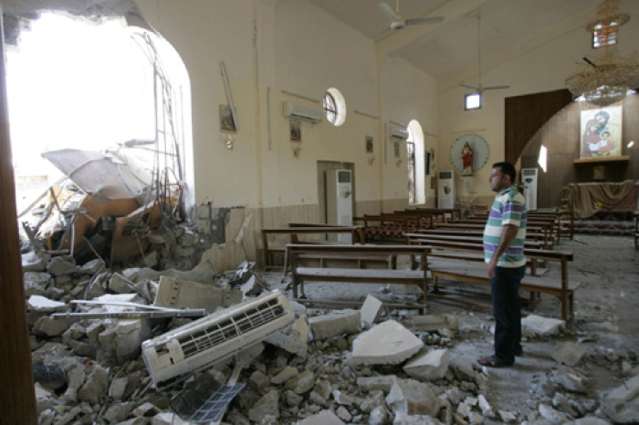 A man stands among debris inside a church after a bomb attack in central Kirkuk, 250 km (155 miles) north of Baghdad August 2, 2011.