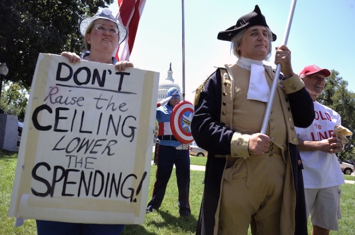 Dozens of Tea Party supporters, including one dressed as Captain America (C) and a George Washington impersonator (R), rally near the U.S. Capitol against raising the debt limit in Washington, July 27, 2011.
