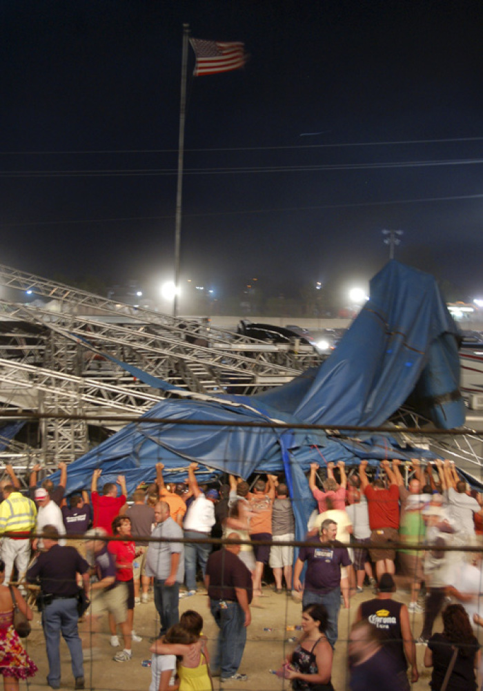 Concertgoers and emergency personnel hold up stage rigging after it collapsed minutes before a concert by Sugarland at the Indiana State Fairgrounds in Indianapolis August 13, 2011. Four people were killed and at least 40 people were hurt when the stage collapsed in windy weather at the fair on Saturday, just minutes before country music duo Sugarland was set to perform.