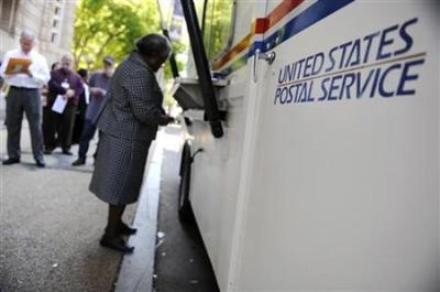 On the deadline day for U.S. citizens to file their income tax returns, a woman stands at the front of the line at a mobile post office near the Internal Revenue Service building in downtown Washington, April 15, 2010.