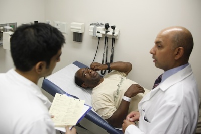 Ernest Sass, 52, (C) listens as Neil Amar, M.D., (L) and Girish Bobby Kapur, M.D. discuss his medical condition in a room used to see patients who don't require treatment for trauma inside the emergency room at Ben Taub General Hospital in Houston, Texas, July 27, 2009. REUTERS/Jessica Rinaldi (UNITED STATES SOCIETY HEALTH POLITICS)