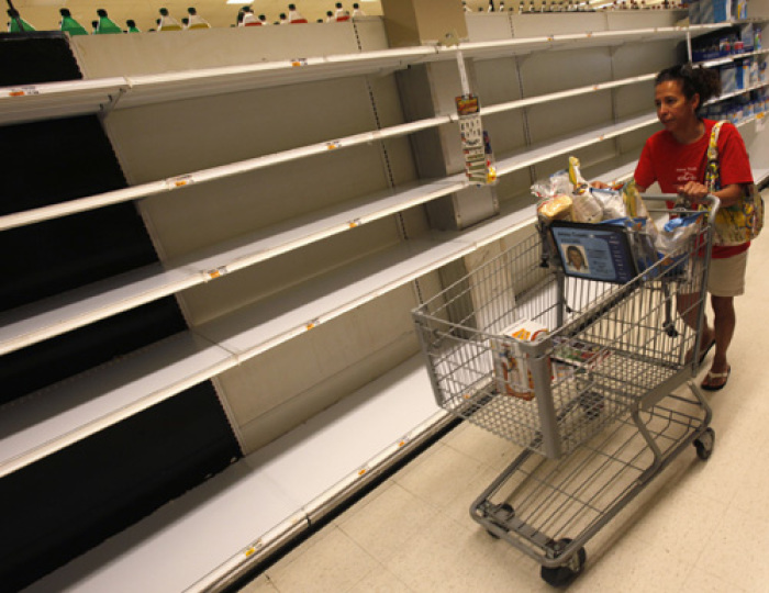 A shopper passes empty shelves while looking for bottled water at a supermarket in Long Beach on Long Island, New York, August 26, 2011. As North Carolina braced on Friday for a direct hit from Hurricane Irene, cities along the East Coast were on alert and millions of beach goers cut short vacations to escape the powerful storm. With more than 50 million people potentially in Irene's path, residents stocked up on food and water and worked to secure homes, vehicles and boats. States, cities, ports, oil refineries and nuclear plants scrambled to activate emergency plans.