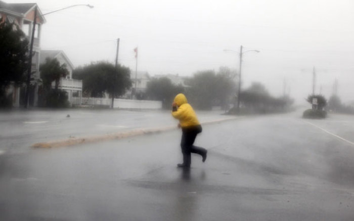 A pedestrian crosses an open area as Hurricane Irene passes through Wrightsville Beach, North Carolina August 27, 2011. Hurricane Irene howled ashore in North Carolina with heavy winds, rain and surf on Saturday on a path threatening the densely populated U.S. East Coast with flooding and power outages.