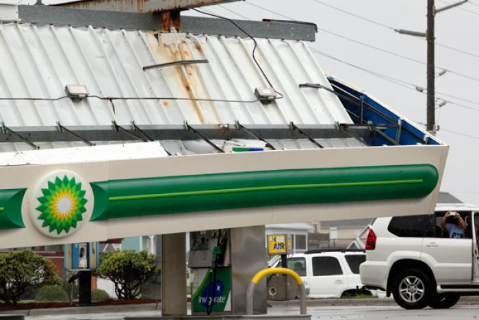 An onlooker takes a photo of a fallen gas canopy hit by Hurricane Irene, at the Atlantic Food Mart in Surf City, N.C., August, 27, 2011.