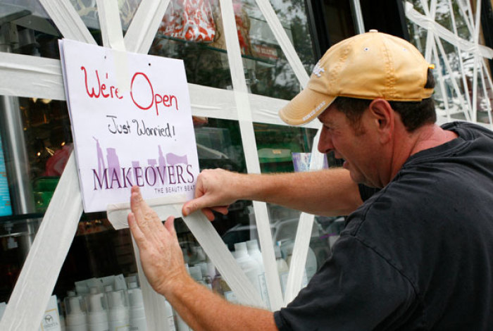 A man puts up a sign after taping up windows for protection against the winds at his business in Hoboken New Jersey, New York August 27, 2011. Some 370,000 of the city's more than 8 million residents are under orders to leave their homes in low-lying and waterfront areas, largely in the boroughs of Brooklyn and Queens and in the financial district in downtown Manhattan.