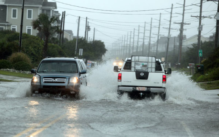 Vehicles are driven through a flooded area during Hurricane Irene in Surf City August 27, 2011.