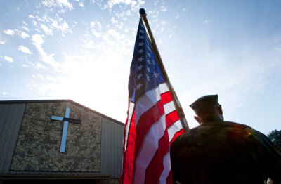 Retired U.S. Marine Charlie Paleveda stands with his American flag outside a church in Gainesville, Florida September 10, 2010.