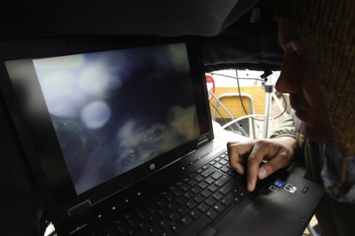 An unidentified individual looks at a computer screen with an image.