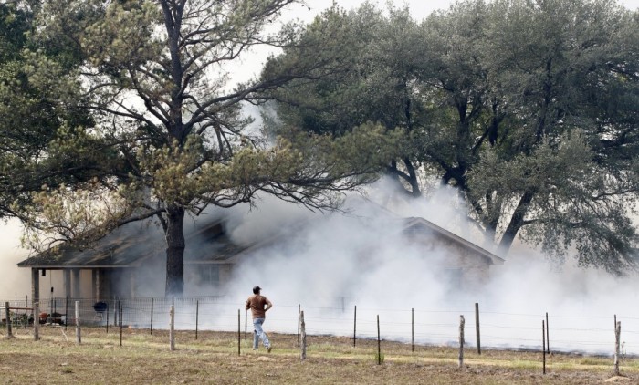 Smoke engulfs a house while a wildfire goes out of control near Bastrop, Texas, September 5, 2011.