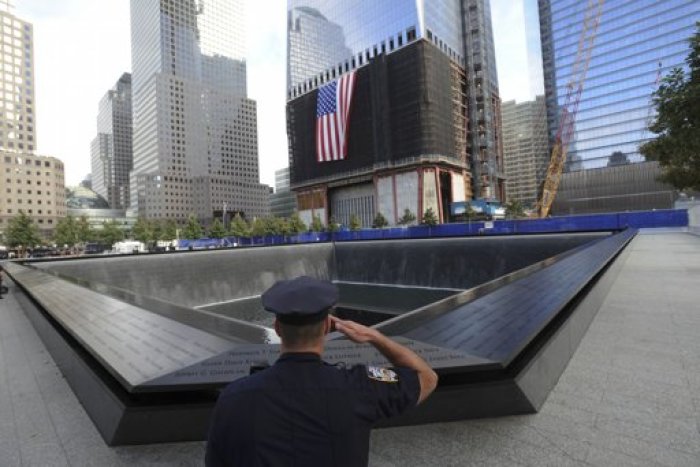 New York City Police Officer Danny Shea, a military vet, salutes at the North pool of the National September 11 Memorial during tenth anniversary ceremonies at the World Trade Center site in New York, September 11, 2011.