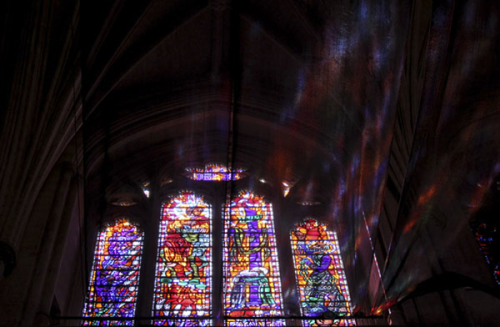 Light shining through a stained glass window falls on nets installed along the ceiling of the National Cathedral's Nave in Washington September 1, 2011.