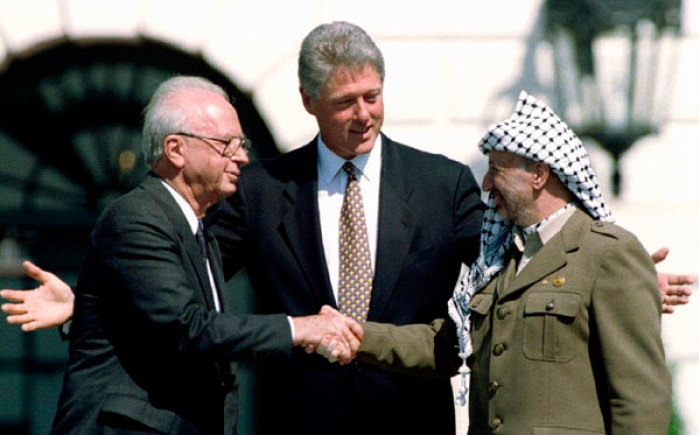 Former U.S. President Bill Clinton (top, C) with former Israeli Prime Minister Yitzhak Rabin (top, L) and Palestine Liberation Organization (PLO) leader Yasser Arafat (top, R) after the signing of the Israeli-PLO peace accord at the White House on September 13, 1993.