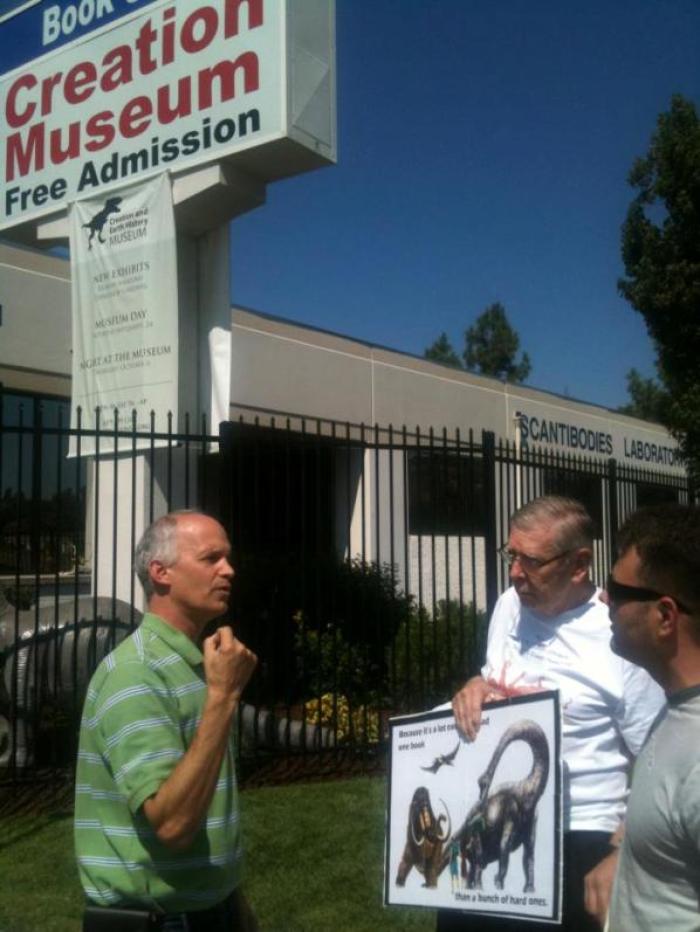 Russell Marechale, Left, brought some middle-school age children from his church to attend the Creation and Earth History's opening of its Human Anatomy Exhibit on Saturday. Later, he said he felt compelled to engage in conversation with a couple of the atheists in front of the museum holding negative signs about creationism, Sept. 24, 2011.