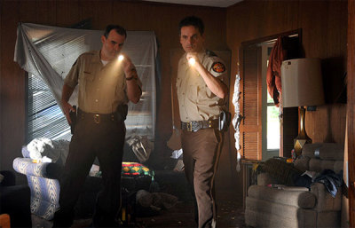 Adam Mitchell, played by Alex Kendrick, and Shane Fuller, played by Kevin Downes, search a home for wanted criminals in a scene from the faith-based film 'Courageous.' 
