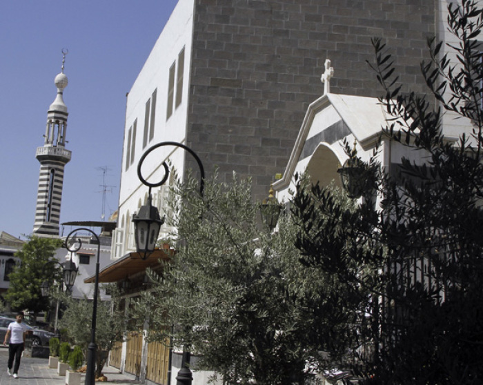 A man walks near a mosque and a church in Old Damascus. Syria's dwindling Christians coexist with their Muslim compatriots in a country where religious minorities often struggle for survival.