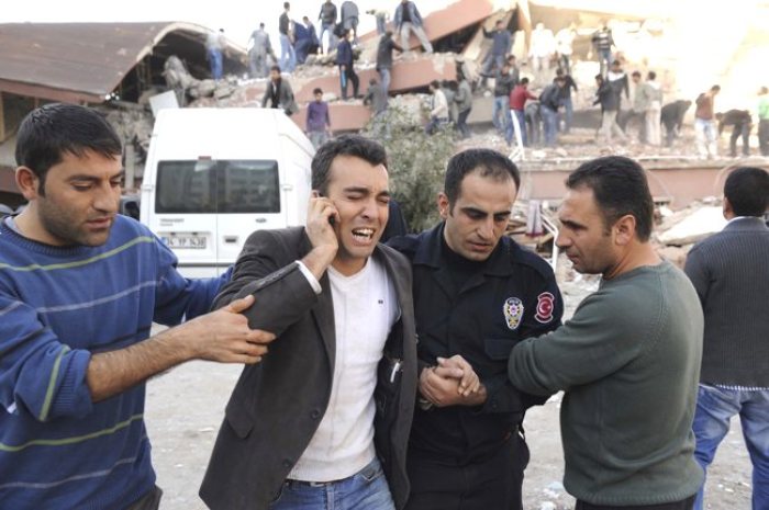 Survivors react as rescue workers try to save people trapped under debris after an earthquake in Tabanli village near the eastern Turkish city of Van on Oct. 23, 2011.