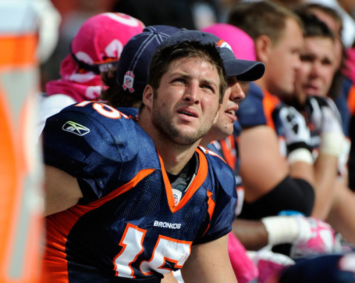 Denver Broncos quarterback Tim Tebow sits on the bench during the first half of a game against the Miami Dolphins in Miami, Florida October 23, 2011.