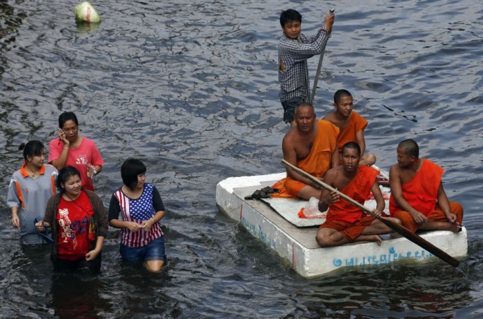 Buddhist monks use a makeshift raft to move in the flooded streets in Bangkok's suburbs.