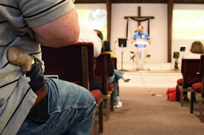A man with a firearm listens to Pastor Ken Pagano during the 'Open Carry Celebration' at New Bethel Church in Louisville, Ky., on June 27, 2009. (File Photo)