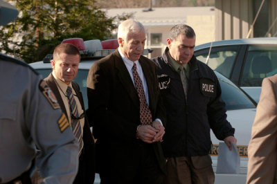 Former Penn State University football defensive coordinator Jerry Sandusky (C) is led away by police after being arrested in a sex crimes investigation, in Harrisburg, Pennsylvania in this November 5, 2011 handout photograph released on November 10. Sandusky was charged with sexually abusing eight young boys over more than a decade, both before and after his retirement from the team in 1999. Picture taken November 5, 2011.