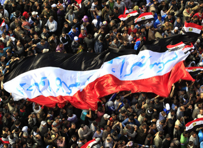 Egyptian protesters march with a huge flag during a rally at Tahrir Square in Cairo November 25, 2011. Egypt's ruling military council appointed Kamal Ganzouri on Friday as prime minister to form 'a national salvation government' to replace the cabinet which resigned this week.