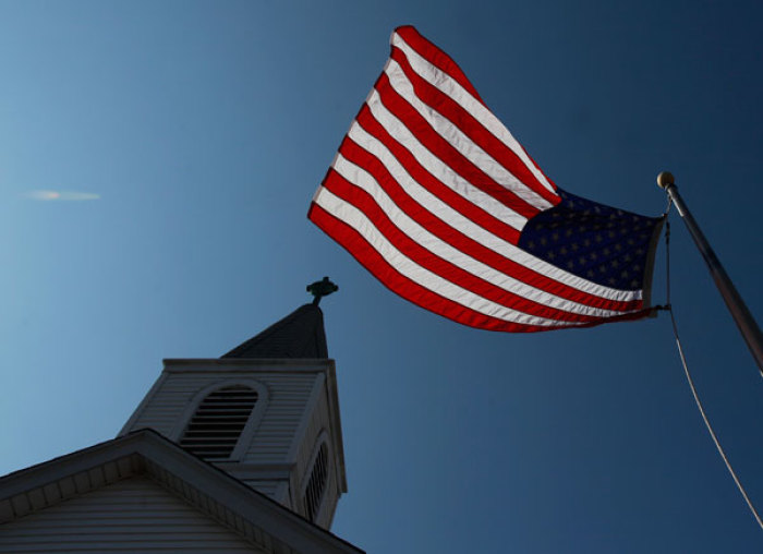 A U.S. flag is seen waving outside a church in the Queens borough of New York August 10, 2011.