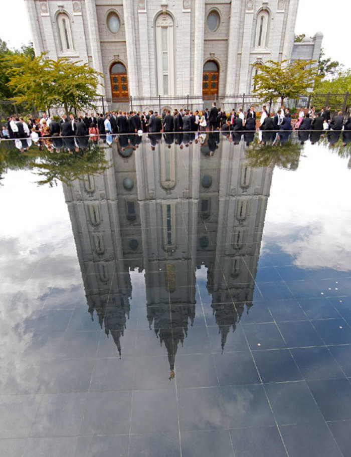 People sit by a reflecting pool outside the Salt Lake Mormon temple as they wait in line to attend the fifth session of the 181st Semiannual General Conference of the Church of Jesus Christ of Latter-day Saints in Salt Lake City, Utah October 2, 2011.