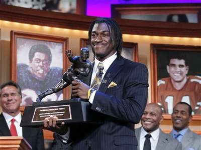 Baylor University quarterback Robert Griffin III, center, holds the Heisman Trophy after winning the award during a ceremony in New York, Dec. 10, 2011.