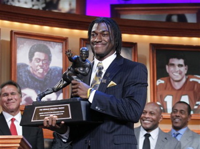 Robert Griffin III, center, holds the Heisman Trophy after winning the award during a ceremony in New York, Dec. 10, 2011.