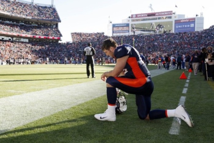 Denver Broncos quarterback Tim Tebow, no. 15, prays near the endzone prior to a game against the Chicago Bears in Denver, Dec. 11, 2011.