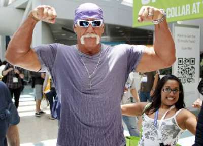 Wrestler Hulk Hogan poses for a photo as a fan also poses as he walks in the Los Angeles Convention Center while on site to promote Majesco Entertainment's 'Hulk Hogan's Main Event' video game on Kinect for Xbox 360 during the Electronic Entertainment Expo or E3 in Los Angeles June 7, 2011.
