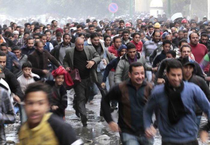Protesters run from troops during clashes in Cairo, Egypt on Dec. 18, 2011.