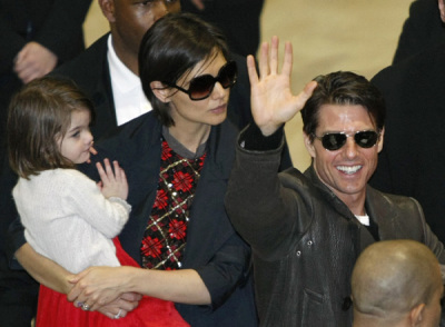 Actor Tom Cruise (R) waves to fans with his wife Katie Holmes (C) and their daughter Suri at Narita International Airport in this March 8, 2009 file photo.